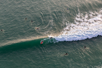 Wave surfers in front of the Plage de Tronoën in Saint-Jean-Trolimon in the state Finistere, France out of the air