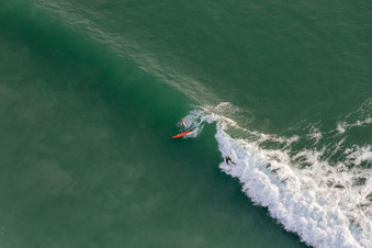 Drone recording of Wave surfers in front of the Plage de Tronoën in Saint-Jean-Trolimon in the state Finistere, France