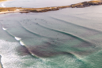 Wave surfers in front of Plage la Torche-Tronoën in Saint-Jean-Trolimon in the state Finistere, France