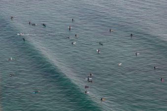 Wave surfers in front of Plage la Torche-Tronoën in Plomeur in the state Finistere, France