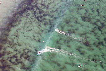Wave surfers in front of the Plage de Tronoën/Bretagne in Plomeur in the state Finistere, France