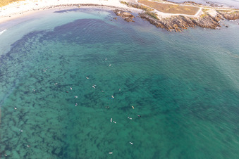 Aerial view of Surfers waiting for the wave in front of the Plage la Torche-Tronoën in Plomeur in the state Finistere, France