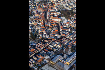 Oblique view of Main street with parish church of St. Michael in winter with snow in Rheinzabern in the state Rhineland-Palatinate, Germany