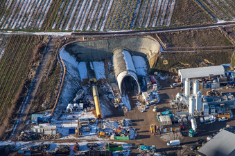 Construction site of the tunnel portal east for the Astrid Tunnel for the underpass and bypass of Bad Bergzabern between B38 (Weinstraße) and B427 (Kurtalstraße) in winter with snow in Dörrenbach in the state Rhineland-Palatinate, Germany from above
