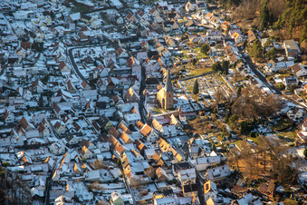 Fortified church of St. Martin and cemetery in winter with snow in Dörrenbach in the state Rhineland-Palatinate, Germany