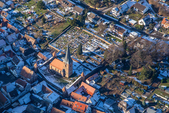 Aerial view of Fortified church of St. Martin and cemetery in winter with snow in Dörrenbach in the state Rhineland-Palatinate, Germany