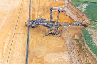 Oblique view of Giant hoisting crane eats into former farmland for the western expansion of the Garzweiler open-cast lignite mine in the district Immerath in Erkelenz in the state North Rhine-Westphalia, Germany