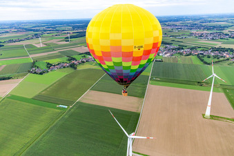Oblique view of Hot air balloon flies close to the wind turbine in the district Straeten in Heinsberg in the state North Rhine-Westphalia, Germany
