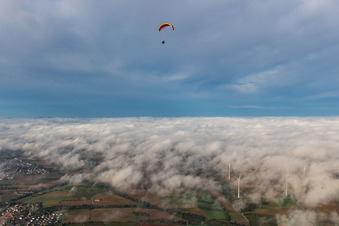 Paraglider over wind farm Freckenfeld in clouds in Freckenfeld in the state Rhineland-Palatinate, Germany