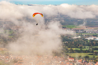 Village with paraglider under autumn clouds in Steinweiler in the state Rhineland-Palatinate, Germany