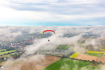 Village with paraglider under autumn clouds in Winden in the state Rhineland-Palatinate, Germany