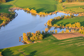 Boardwalks with fishing huts line the shore of Lake Etang du Welschhof. in Puttelange-aux-Lacs in the state Moselle, France