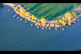 Boardwalks with fishing huts line the shore of Lake Etang du Welschhof. in Puttelange-aux-Lacs in the state Moselle, France