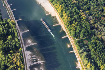 Empty cargo ship at low water on the Rhine between Hördter Rheinaue and Dettenheim in Hördt in the state Rhineland-Palatinate, Germany