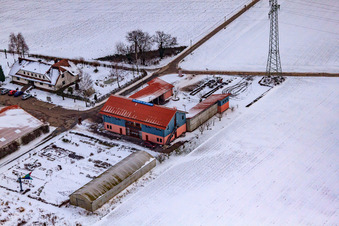 Oblique view of Village market Schoßberghof In winter with snow in Minfeld in the state Rhineland-Palatinate, Germany
