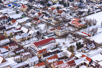 Aerial view of Village square with primary school in snow in Freckenfeld in the state Rhineland-Palatinate, Germany