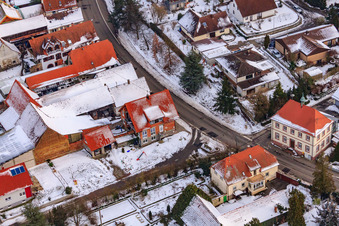 Main street in winter in the snow in Hergersweiler in the state Rhineland-Palatinate, Germany from the plane