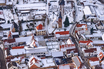 Aerial view of Raiffeisenstraße x Kirchstraße in snow in Winden in the state Rhineland-Palatinate, Germany