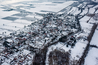 Aerial view of Wintry snowy Village - view on the edge of agricultural fields and farmland in Winden in the state Rhineland-Palatinate, Germany