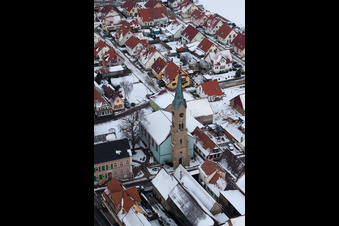Winter snow-covered church buildings in the village center in Erlenbach bei Kandel in the state Rhineland-Palatinate, Germany