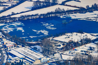 Quarry lake in winter with snow in the district Neureut in Karlsruhe in the state Baden-Wuerttemberg, Germany