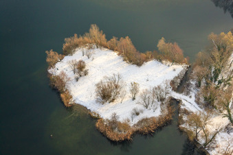 Peninsula in the Johanneswiese quarry lake in winter with snow in Jockgrim in the state Rhineland-Palatinate, Germany