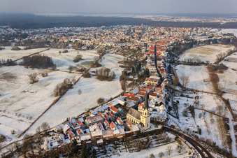 Oblique view of St. Dionysius in Hinterstädel in winter with snow in Jockgrim in the state Rhineland-Palatinate, Germany