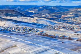 Wine-growing village under the Keschdebusch vineyard in winter with snow in Birkweiler in the state Rhineland-Palatinate, Germany