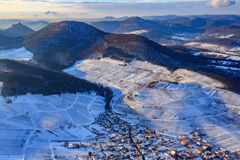Oblique view of Wine-growing village under the Keschdebusch vineyard in winter with snow in Birkweiler in the state Rhineland-Palatinate, Germany