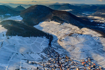 Wine-growing village under the Keschdebusch vineyard in winter with snow in Birkweiler in the state Rhineland-Palatinate, Germany from above