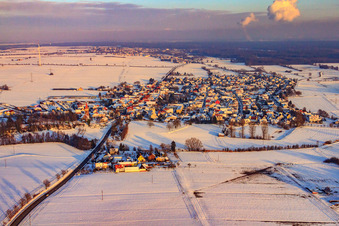 Village view in the evening light with snow in winter from the west in Minfeld in the state Rhineland-Palatinate, Germany