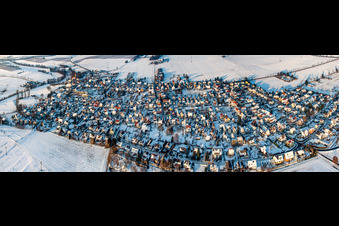Village view in the evening light with snow in winter from the south in Minfeld in the state Rhineland-Palatinate, Germany