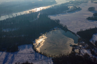 Frozen quarry lake in snow in winter in Lauterbourg in the state Bas-Rhin, France