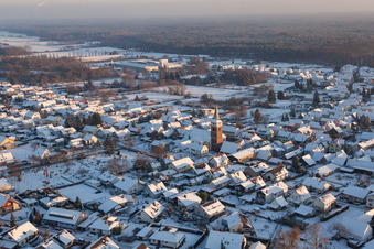 Aerial view of Wintry snowy Church building in the village of in the district Schaidt in Woerth am Rhein in the state Rhineland-Palatinate, Germany