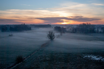Aerial view of Colorful sunrise over the countryside in Minfeld in the state Rhineland-Palatinate dyes the sky orange and yellow