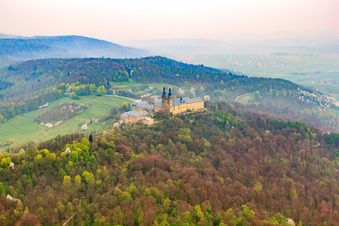Oblique view of Banz Monastery with the monastery church of St. Dionysius and St. Peter on a mountain above the Main in the district Unnersdorf in Bad Staffelstein in the state Bavaria, Germany
