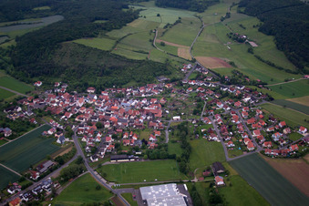 Aerial view of Village - view on the edge of agricultural fields and farmland in Karsbach in the state Bavaria, Germany