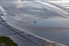 Fishing boat returning home in the evening along the river mouth of Eider into the North Sea in Karolinenkoog in the state Schleswig-Holstein, Germany