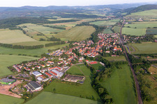 Agricultural land and field boundaries surround the settlement area of the village in Mechterstaedt in the state Thuringia, Germany