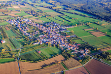 Village overview between autumnal fields and meadows with St. Laurentius Church from the northwest in Schweighofen in the state Rhineland-Palatinate, Germany