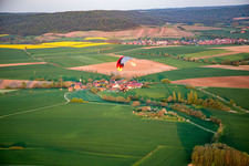 Aerial view of Paraglider over the town in the district Wiebelsberg in Oberschwarzach in the state Bavaria, Germany