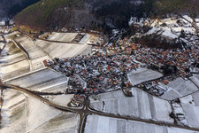 View of a winegrowing village on the edge of the Haardt in winter between snow-covered vineyards from the east in Gleisweiler in the state Rhineland-Palatinate, Germany