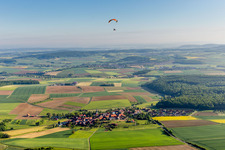 Paraglider over the village in the district Altenmünster in Stadtlauringen in the state Bavaria, Germany