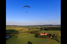 Aerial view of Paraglider over the estate Mariaburghausen with the Church of St. John the Baptist Mariaburghausen in the district Mariaburghausen in Haßfurt in the state Bavaria, Germany