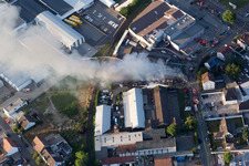 Smoke and flames during the fire fighting to fire of a storage all for antiqities in the Werkstrasse in Speyer in the state Rhineland-Palatinate, Germany from above