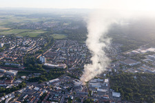 Smoke and flames during the fire fighting to fire of a storage all for antiqities in the Werkstrasse in Speyer in the state Rhineland-Palatinate, Germany viewn from the air