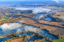 Dredging lakes for gravel extraction by Kieswerk Wolf and Finger Beton Kuhardt GmbH under clouds in Leimersheim in the state Rhineland-Palatinate, Germany