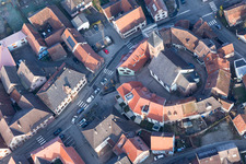 Protestantic Church building in the center of a circle of houses in the village of in Dossenheim-sur-Zinsel in Grand Est, France seen from above