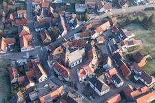 Protestantic Church building in the center of a circle of houses in the village of in Dossenheim-sur-Zinsel in Grand Est, France from the drone perspective