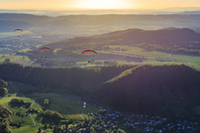 Three paragliders in the morning in Holenberg in the state Lower Saxony, Germany